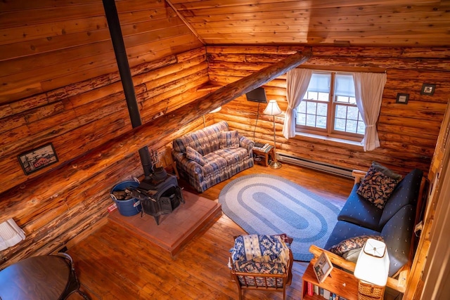 living room featuring vaulted ceiling, hardwood / wood-style floors, rustic walls, and a baseboard heating unit