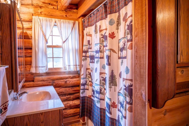 full bathroom with vanity, curtained shower, and rustic walls