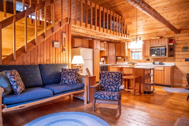 living room with wooden ceiling, wooden walls, light wood-style flooring, and beam ceiling