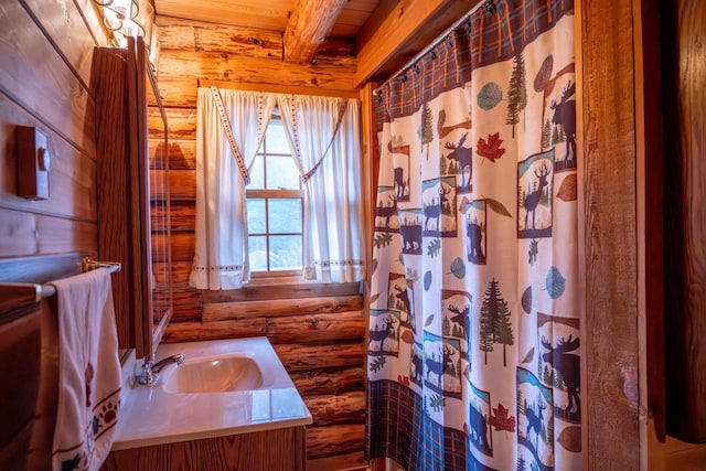 full bath with a shower with curtain, beam ceiling, wooden ceiling, rustic walls, and vanity