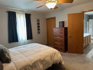 bedroom with ensuite bath and a ceiling fan