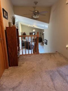 unfurnished living room featuring carpet and a ceiling fan