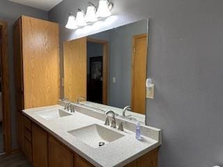 bathroom featuring a sink, double vanity, and a notable chandelier