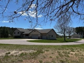 view of front of property with concrete driveway, an attached garage, and a front yard