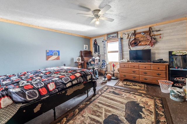 bedroom with wooden walls, a textured ceiling, a ceiling fan, and concrete floors
