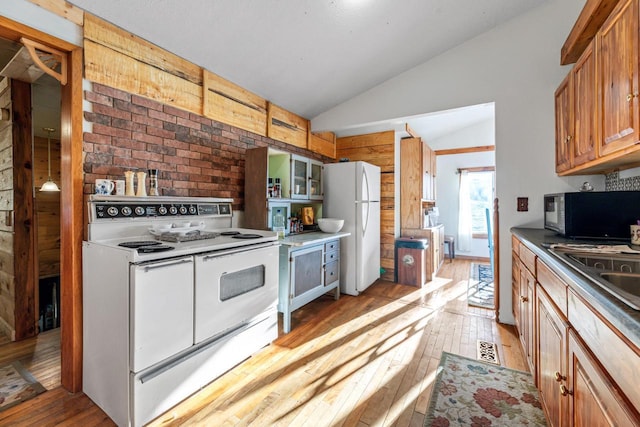 kitchen featuring a sink, lofted ceiling, white appliances, glass insert cabinets, and light wood-style floors