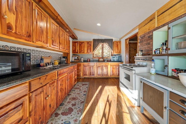 kitchen featuring white electric stove, stainless steel microwave, dark wood-style floors, vaulted ceiling, and black microwave