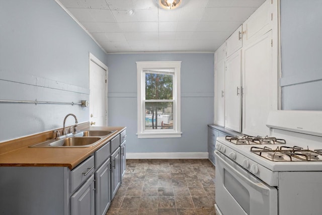3303 W Juneau Ave Unit 3311, Milwaukee, WI 53208 - kitchen featuring a sink, white range with gas cooktop, stone finish flooring, gray cabinetry, and baseboards