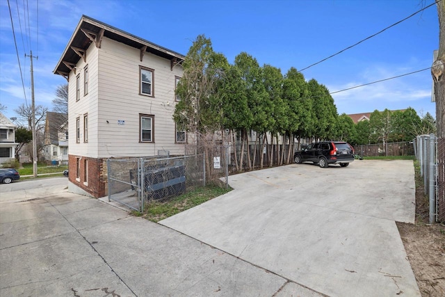 3303 W Juneau Ave Unit 3311, Milwaukee, WI 53208 - view of side of property with brick siding, driveway, fence, and a gate