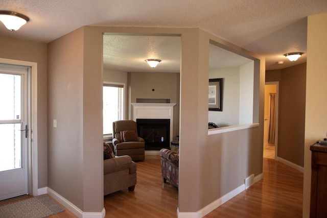 416 Gannon Ct, Tomah, WI 54660 - entrance foyer featuring a fireplace, a textured ceiling, baseboards, and wood finished floors