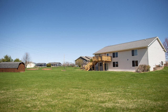 416 Gannon Ct, Tomah, WI 54660 - rear view of house with a storage unit, a deck, a lawn, an outbuilding, and stairs