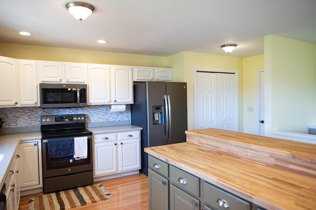 416 Gannon Ct, Tomah, WI 54660 - kitchen with white cabinetry, appliances with stainless steel finishes, and butcher block countertops