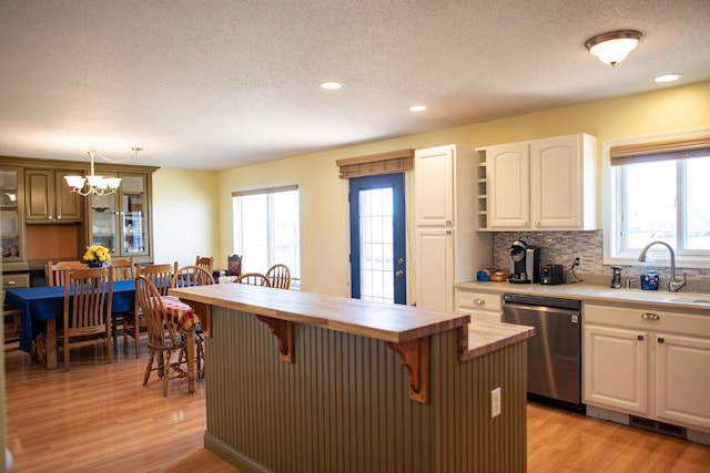 416 Gannon Ct, Tomah, WI 54660 - kitchen featuring a sink, a kitchen breakfast bar, light wood-style flooring, stainless steel dishwasher, and wooden counters