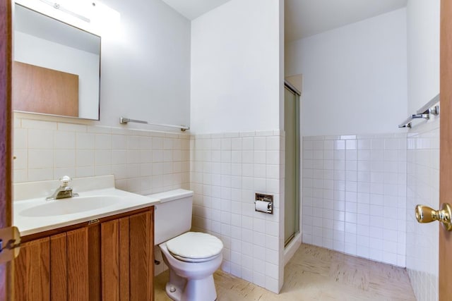 W10940 W Harmony Dr, Lodi, WI 53555 - bathroom featuring tile walls, a shower stall, toilet, vanity, and wainscoting