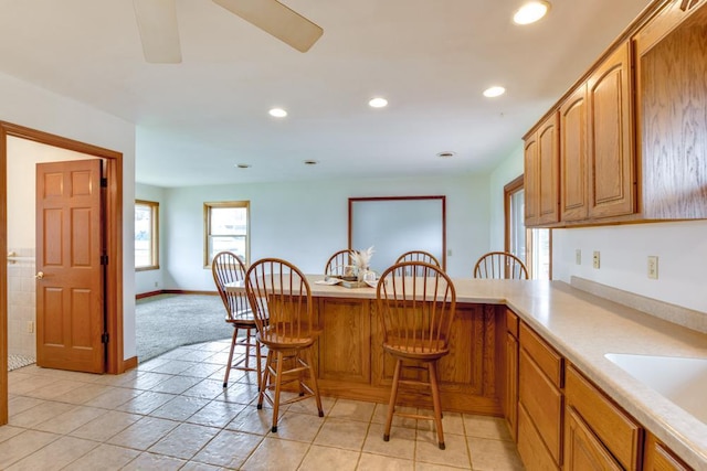 W10940 W Harmony Dr, Lodi, WI 53555 - kitchen with a breakfast bar, a peninsula, light countertops, recessed lighting, and a sink