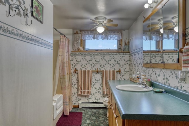 bathroom with vanity, a baseboard radiator, a ceiling fan, a shower with shower curtain, and wallpapered walls