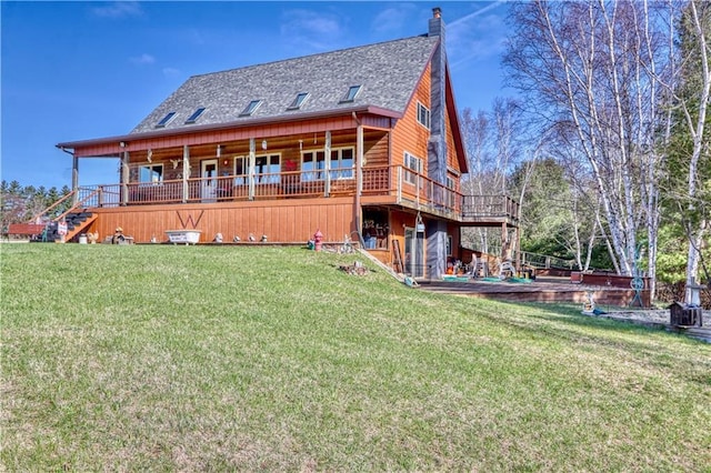 rear view of property featuring a chimney, a wooden deck, a lawn, roof with shingles, and stairs