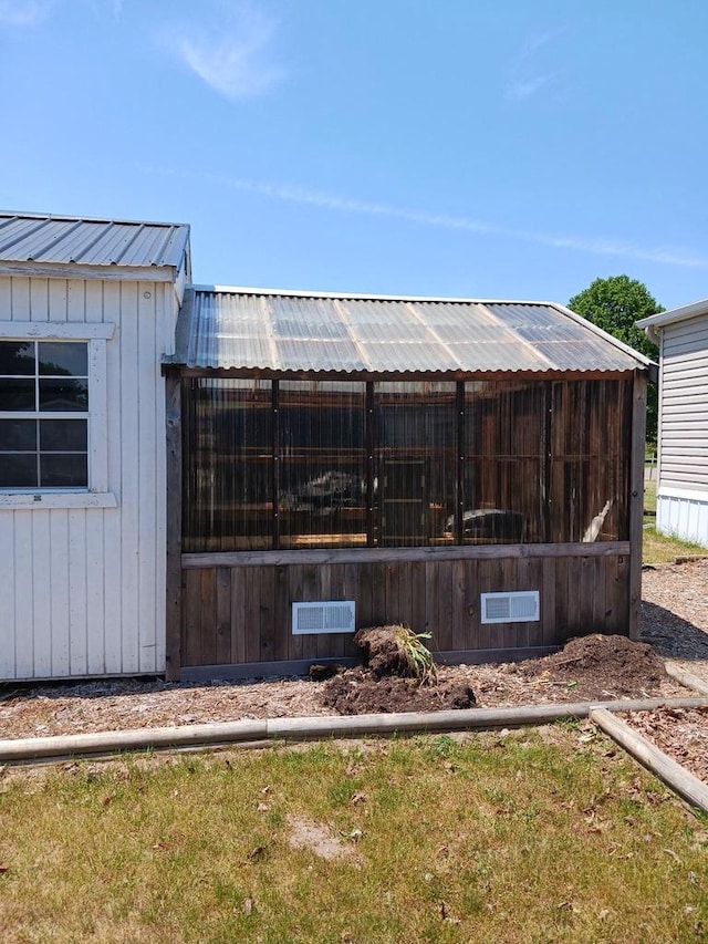 exterior space with an outbuilding and metal roof