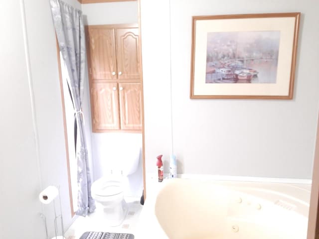 bathroom featuring toilet and a jetted tub