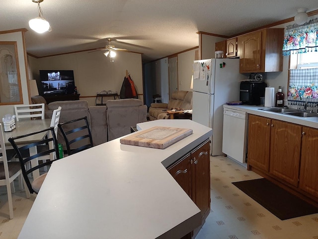kitchen featuring a sink, crown molding, light floors, and white appliances