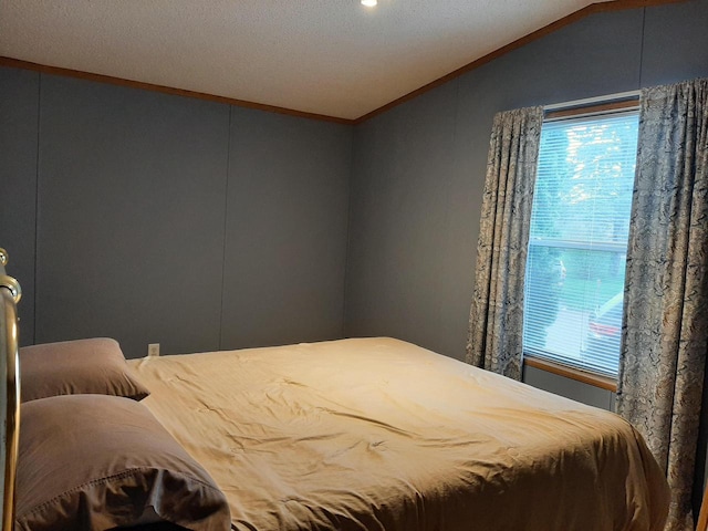 bedroom featuring multiple windows, lofted ceiling, and ornamental molding