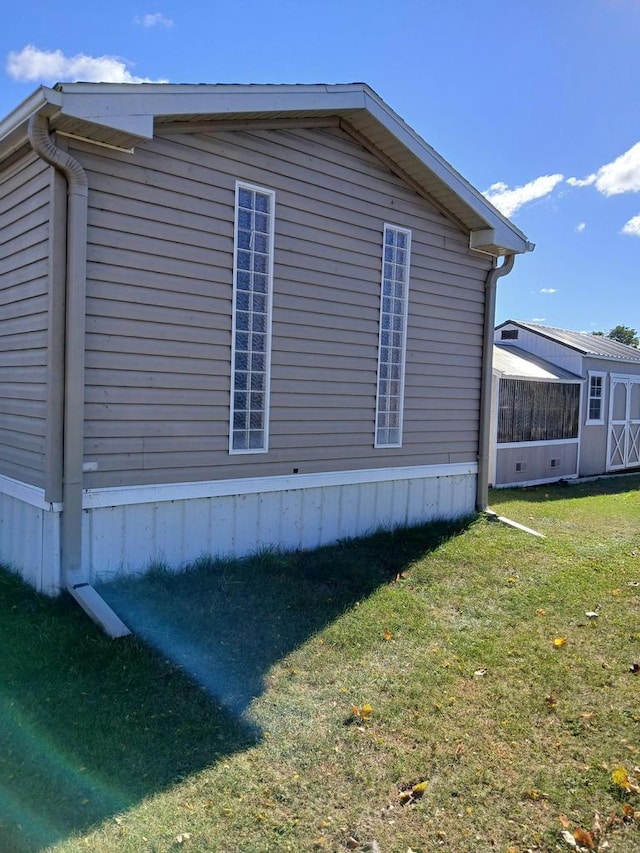 view of home's exterior with a lawn, an outbuilding, and a shed