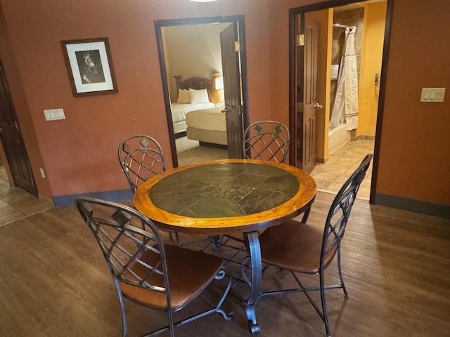 dining space featuring wood finished floors and baseboards
