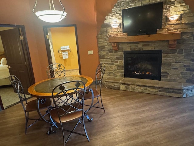 dining area with wood finished floors and a fireplace