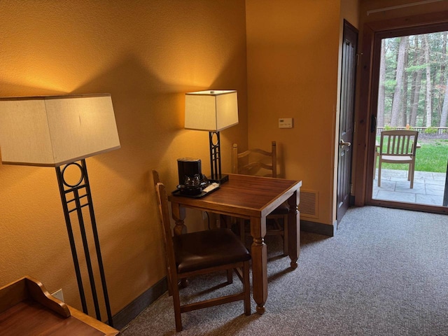 carpeted office space featuring visible vents and baseboards