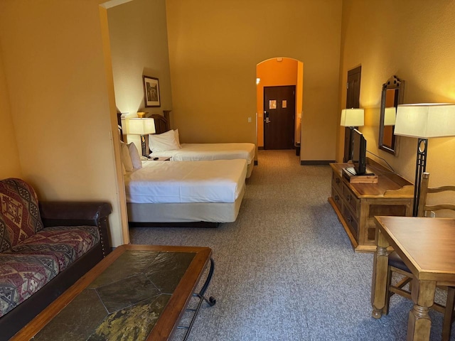 bedroom featuring carpet flooring and arched walkways