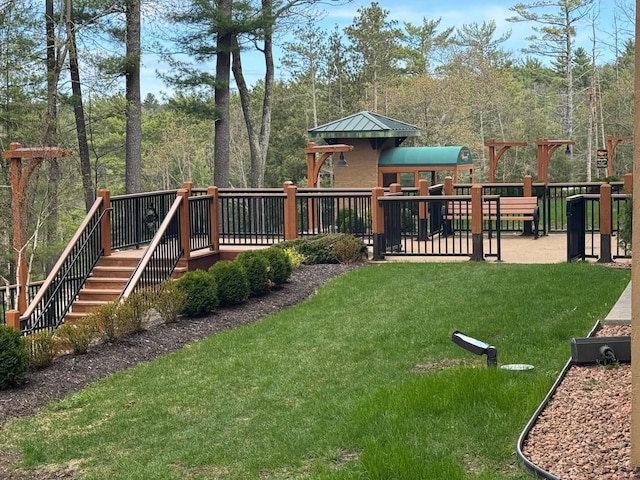 view of playground with stairway, a wooden deck, and a lawn