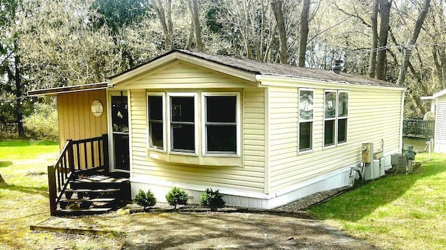 exterior space with central air condition unit and a front lawn