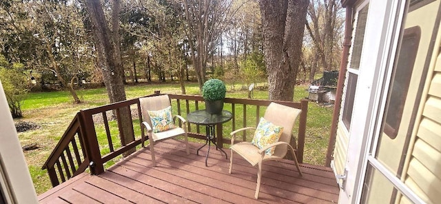 wooden deck featuring a lawn
