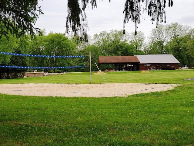 view of home's community featuring volleyball court and a lawn