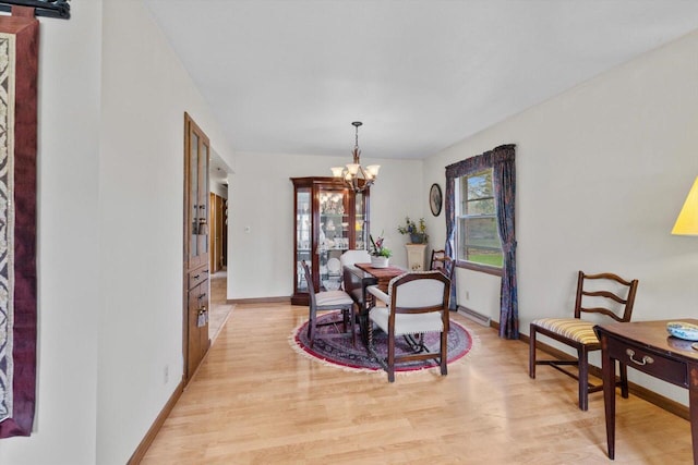 dining space with an inviting chandelier, plenty of natural light, and light wood-style floors