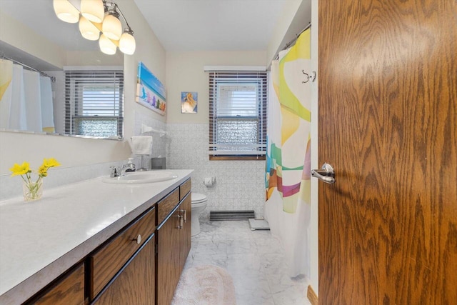 bathroom with toilet, tile walls, curtained shower, marble finish floor, and vanity