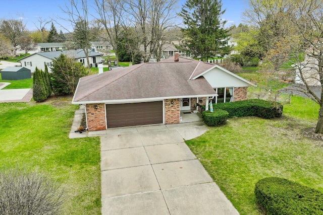 view of front facade with an attached garage, concrete driveway, a front yard, brick siding, and roof with shingles