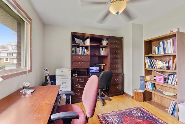 home office with light wood-type flooring and ceiling fan