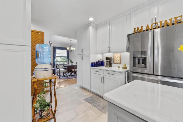kitchen featuring a notable chandelier, recessed lighting, light stone counters, stainless steel fridge with ice dispenser, and white cabinets
