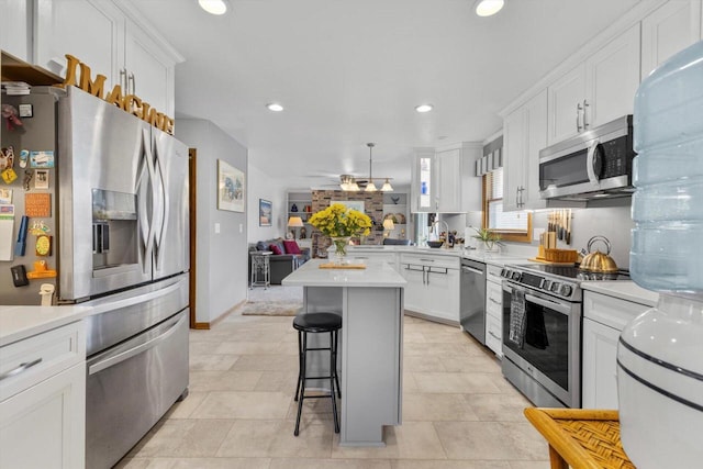 kitchen featuring white cabinets, light countertops, a breakfast bar area, and stainless steel appliances
