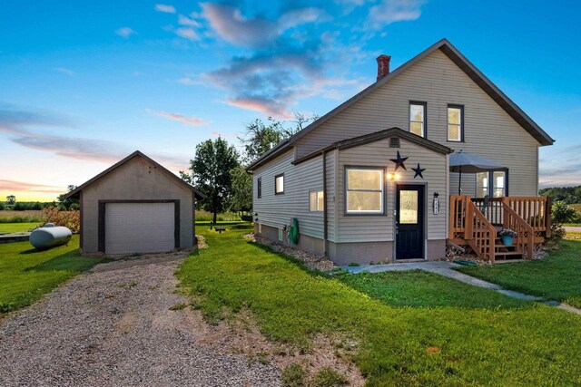 W444 Carlson Ln, Oconto Falls, WI 54154 - view of front of home featuring a garage, a yard, an outdoor structure, and gravel driveway