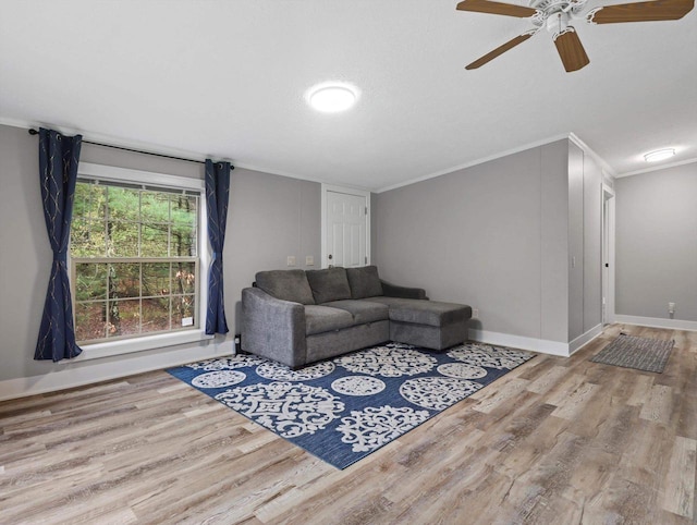 living room featuring crown molding, baseboards, a ceiling fan, and wood finished floors