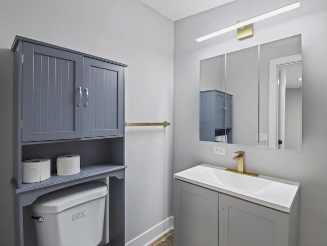 bathroom with toilet, wood finished floors, and vanity