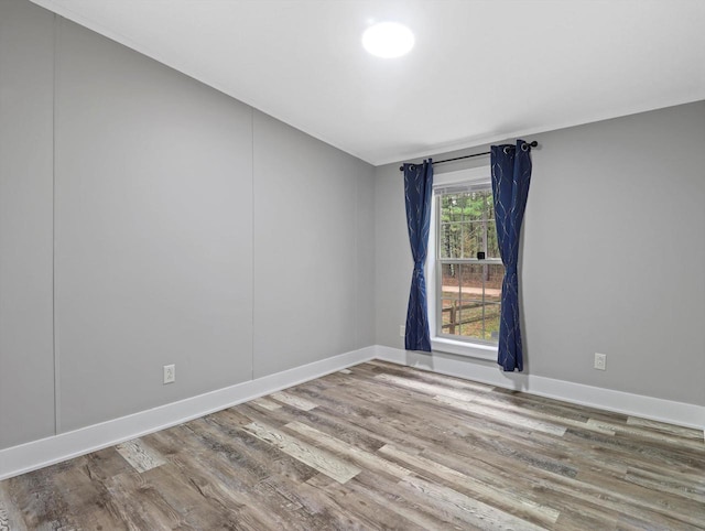 empty room featuring wood finished floors and baseboards