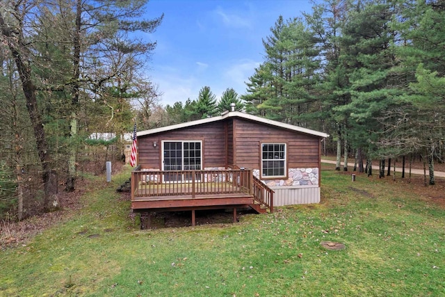rear view of property with a deck and a lawn