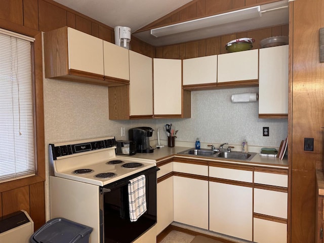 kitchen with light countertops, white cabinetry, a sink, and electric stove