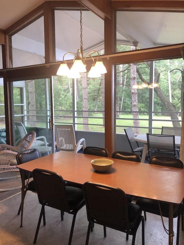 dining room with an inviting chandelier, lofted ceiling, and a healthy amount of sunlight
