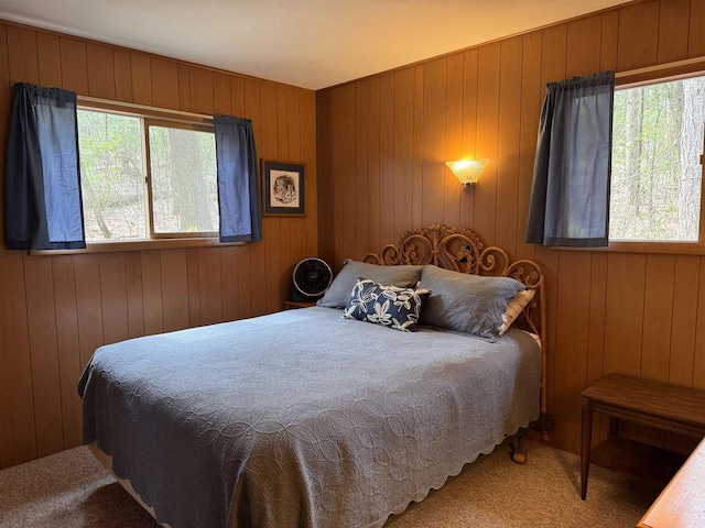 carpeted bedroom featuring wood walls