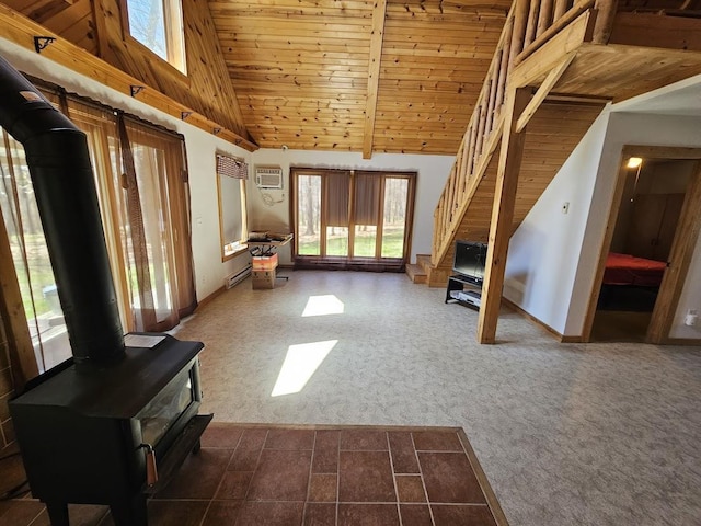 unfurnished living room featuring carpet, a wood stove, wooden ceiling, and plenty of natural light