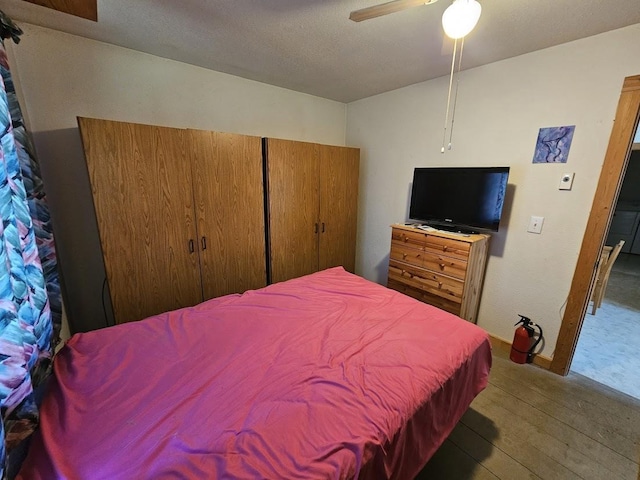 bedroom with hardwood / wood-style flooring, a closet, and a ceiling fan
